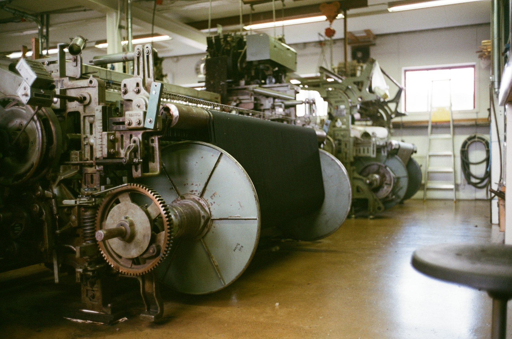 Rangée de métiers industriels textile, vue en enfilade avec fils de chaîne tendus